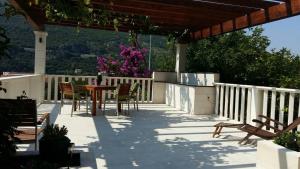 Un patio con una mesa y sillas en una terraza. en Apartments Husanovic, en Mokošica