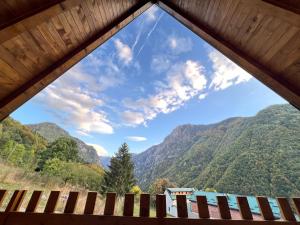 una ventana con vistas a las montañas desde una cabaña en Villa Dardania, en Peje