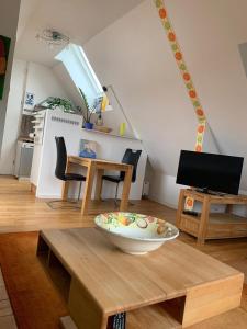 ein Wohnzimmer mit einem Tisch und einer Schüssel darauf in der Unterkunft Dachwohnung Nähe Clemenshospital in Münster