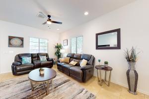 a living room with leather furniture and a ceiling fan at Golden Marigold Sanctuary in Buckeye