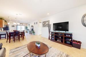 a living room with a tv and a dining room at Golden Marigold Sanctuary in Buckeye +24 photos