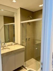 une salle de bain avec une douche en verre avec un lavabo dans l'établissement Flats Boa Viagem Rooftop470, à Récife