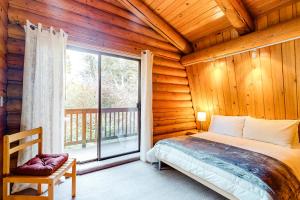 ein Schlafzimmer mit einem Bett und einem großen Fenster in der Unterkunft Rocky's Log Cabin in Sultan