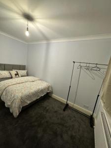 a bedroom with a bed and a white wall at Chi Lodge & Accommodation in Rainham