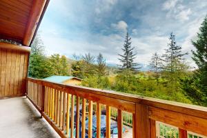 einen Balkon einer Hütte mit Waldblick in der Unterkunft Rocky's Log Cabin in Sultan