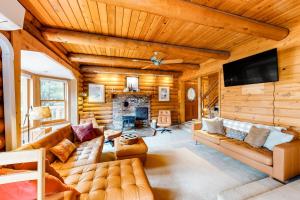 a living room with a couch and a fireplace at Rocky's Log Cabin & Retreat in Sultan