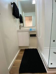 baño con espejo y alfombra negra en Sand Hollow Zion Mini Home at Painted Sands 2, en Hurricane 28 fotos más