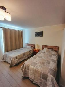 1 dormitorio con 2 camas y ventana en Departamento Central, en Calama