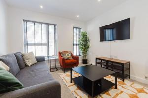 a living room with a couch and a table at 4-Level Luxury 2 Bedroom House Sleeps 6, Rooftop, Harry P & Free Parking in Watford
