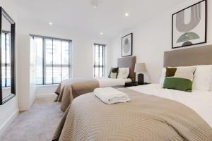 a bedroom with two beds and two windows at 4-Level Luxury 2 Bedroom House Sleeps 6, Rooftop, Harry P & Free Parking in Watford