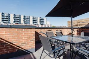 a table and chairs on a roof with an umbrella at 4-Level Luxury 2 Bedroom House Sleeps 6, Rooftop, Harry P & Free Parking in Watford