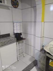 eine Küche mit weiß gefliesten Wänden und einer Theke in der Unterkunft Casa da Serra Centro in Guaramiranga