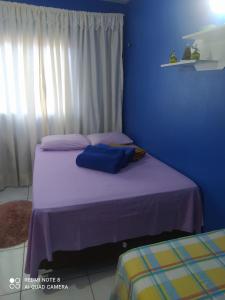 1 dormitorio con 2 camas y pared azul en Casa da Serra Centro en Guaramiranga