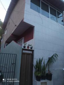 un edificio con una puerta y macetas. en Casa da Serra Centro en Guaramiranga