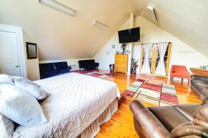 um quarto com uma cama branca e um sofá em The Sasquatch Loft em Cave Junction