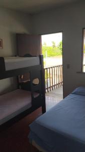 a bedroom with two bunk beds and a balcony at Pousada Lua Branca in Tutóia