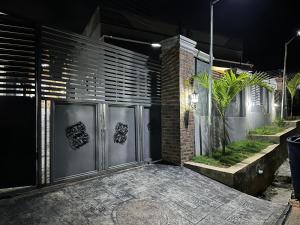 eine Garage mit einem Metalltor und einer Ziegelwand in der Unterkunft Ethan’s Court in Ibadan