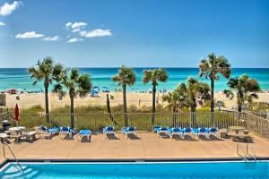 a swimming pool with chairs and a beach at Gulf Highland, Unit A in Panama City Beach