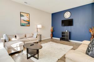 a living room with a couch and a clock on the wall at Spacious Camby Home with Community Pool and Park! in Camby