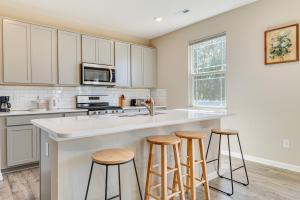 a kitchen with white cabinets and bar stools at Spacious Camby Home with Community Pool and Park! in Camby