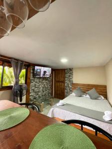 a bedroom with two beds and a table and a tv at Dreams Lodge Orosi in Cartago