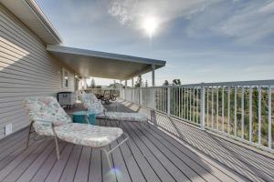 a deck with two chairs and a grill on it at Spacious Canyon Ferry Lake House with Bar and Views! in Helena