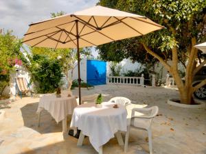 two tables and an umbrella on a patio at Henchir ejdoud in Kairouan