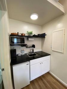 eine kleine Küche mit weißen Schränken und einer Spüle in der Unterkunft Mini Desert Oasis at Painted Sands 3 in Hurricane