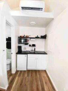 eine weiße Küche mit Spüle und Mikrowelle in der Unterkunft Mini Desert Oasis at Painted Sands 3 in Hurricane + 24 Fotos