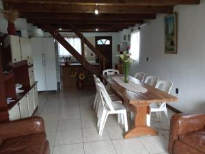 a dining room with a wooden table and white chairs at Casa de Cristina in Costa Azul