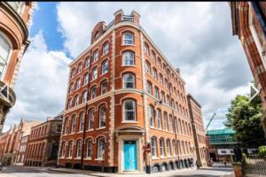 a large red brick building with a blue door at Flat in Nottingham City Centre in Nottingham