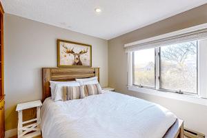 a bedroom with a white bed and a window at Barefoot Bliss in Kennebunk