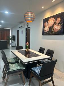 uma mesa de jantar com cadeiras e um quadro na parede em Armadale Residence-Gala City em Kuching