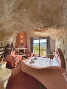 a bedroom in a cave with two people laying on a bed at Anemoessa in Synikia Mesi Trikalon