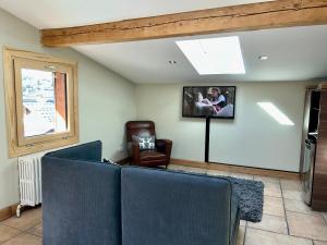 uma sala de estar com duas cadeiras e uma televisão na parede em Penthouse Apartment, 2 Bedroom, 2 Bathroom em Chamonix-Mont-Blanc