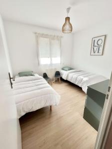 um quarto com três camas com um pingente em Maison Piscine Spa près bordeaux em Ambarès-et-Lagrave