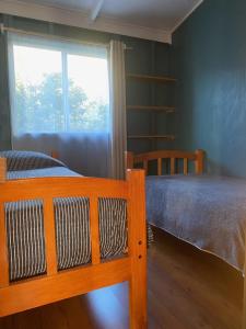 a bedroom with a bed and a window at Los alamos in Puerto Tranquilo