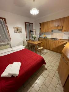 ヴェネツィアにあるBeautiful Veniceのベッドルーム1室(赤いベッド1台付)、キッチンが備わります。