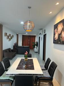 een woonkamer met een tafel en stoelen en een bank bij Armadale Residence-Gala City in Kuching