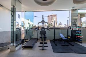 a gym with a view of a city at Nilmare Apart Hotel in Itapema