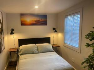 een bed in een kamer met een raam en een bed sidx sidx sidx bij Cozy 1BR ADU Nestled in Foothill in Oakland