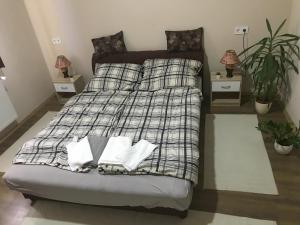1 dormitorio con cama con almohadas y manta en Vállaj Vendégház, en Vállaj