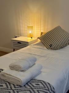 a bed with towels on it with a nightstand and a lamp at Modern Apartment X91 R940 in Waterford