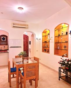a dining room with a table and chairs and shelves at West golf 2bedroom in Hurghada
