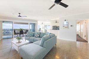 uma sala de estar com um sofá e uma ventoinha de tecto em Seaside Serenity Tranquil Retreat in Scenic Cullen Bay em Larrakeyah