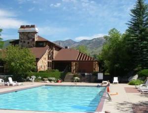 a house with a swimming pool in front of a building at Perfect Mt. Location! Skiing, Hiking, Biking, Pool in Eden
