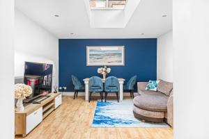 uma sala de estar com uma mesa e uma parede azul em Central 2Bed Mew in Marylebone em Londres