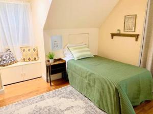 Un dormitorio con una cama verde y una ventana en Peoria Speedway Rocky Glen Bradley Park 4bdrm Home, 