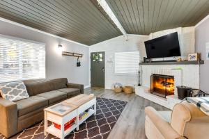 een woonkamer met een bank en een open haard bij Sugarloaf Cabin with Fireplace Near Big Bear Lake in Sugarloaf