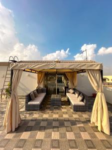 ein Pavillon mit Sofas auf einer Terrasse in der Unterkunft 2BD Apartment in a rooftop with a private terrace in Kairo